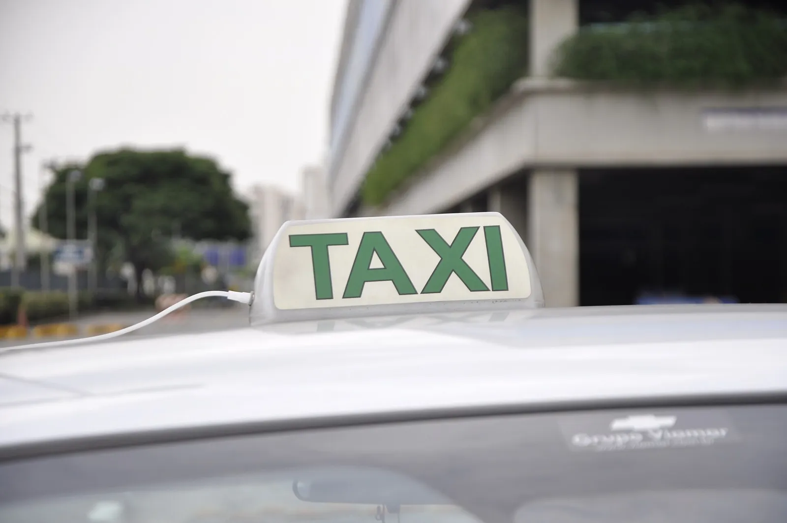 Luminoso de táxi verde e branco no teto do carro